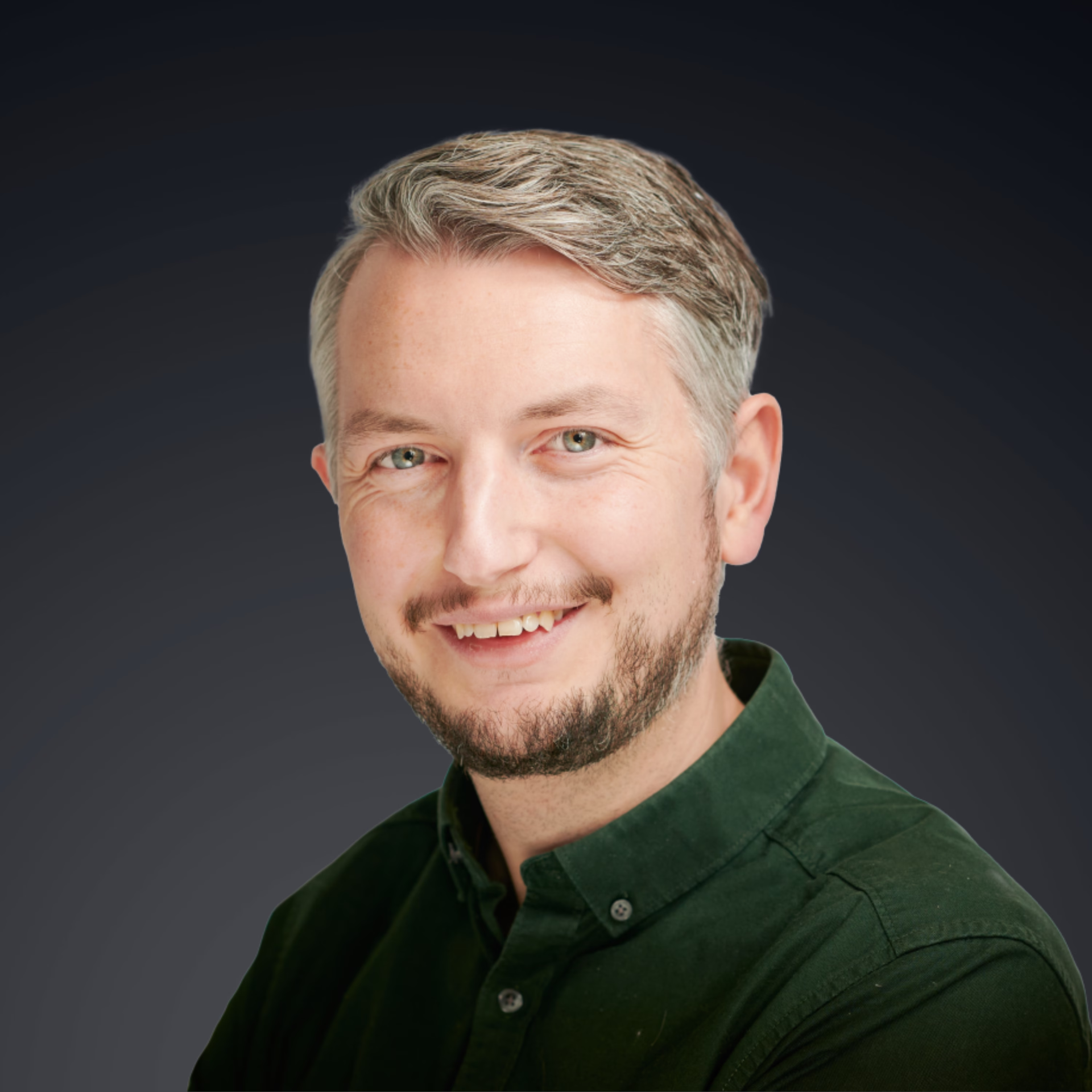 Aidan Murphy, senior communications consultant, smiling in a dark green shirt against a charcoal backdrop